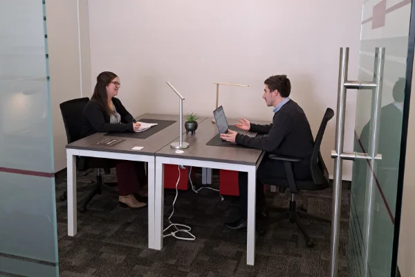 Two colleagues discussing at a modern office desk.